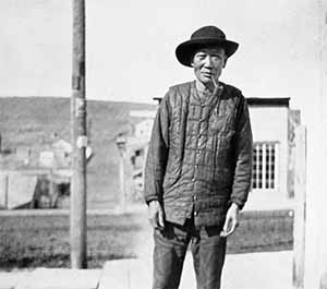 Chinese man with a pipe on the streets of Virginia City.